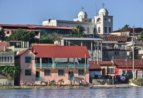 弗洛勒斯Hostal Don Cenobio的水边有红色屋顶的建筑