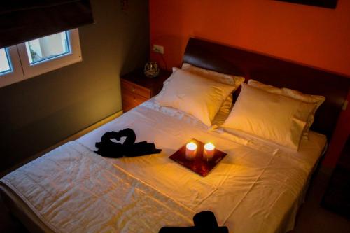 帕斯蒂达Sunshine penthouse的卧室配有一张床上的2把蜡烛