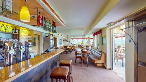 阿特湖Hotel Haberl - Attersee的餐厅设有酒吧,配有桌椅