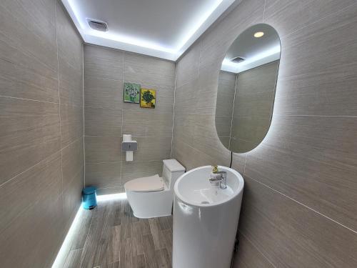 江陵市尤吉特吉恩浦酒店的一间带水槽、卫生间和镜子的浴室