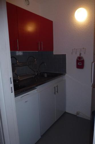 勒克比尔Larnica的一个带水槽和红色橱柜的厨房