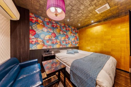 东京HOTEL Lotus Ikebukuro (Adult Only)的小房间设有床和蓝色的沙发