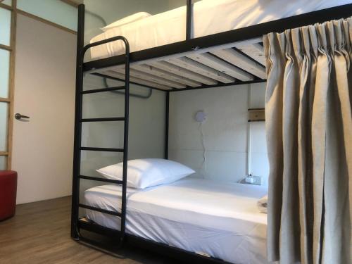 台南Simple Walk Guest House 小公寓-可包棟的卧室配有2张双层床和白色床单