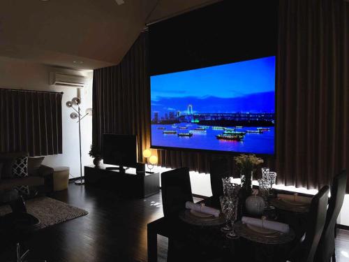 广岛OUCHI HOTEL SUITE Temma的客厅配有壁挂式大屏幕平面电视