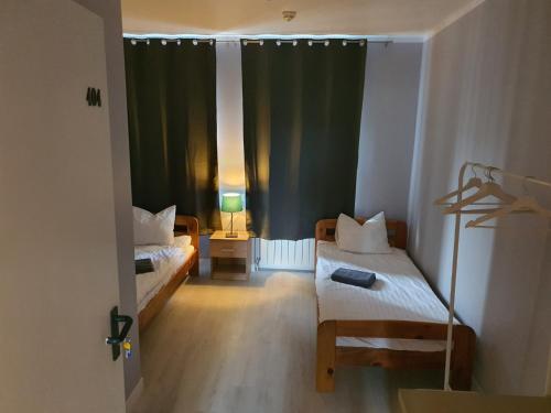 华沙Jasna Hotelik的小房间设有两张床和窗户