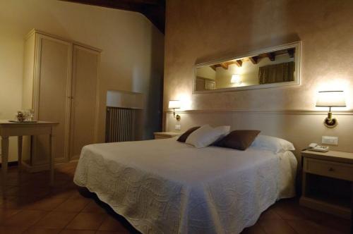 托斯科拉诺-马德尔诺Albergo CAVALLINO 10的卧室配有一张床,墙上设有镜子