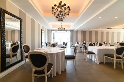 帕埃斯图姆索加利斯酒店的一间带桌椅和吊灯的用餐室