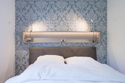 StahlbrodeFerienhaus Rügenblick的床头板,床上贴着蓝色和白色的壁纸