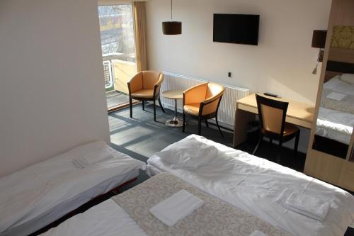 AuningAuning Kro的酒店客房带两张床和一张桌子以及椅子。
