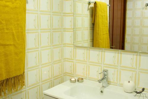 雷凯蒂奥Piso en Lekeitio, Costa Vasca, Bizkaia.的浴室设有水槽、镜子和黄毛巾