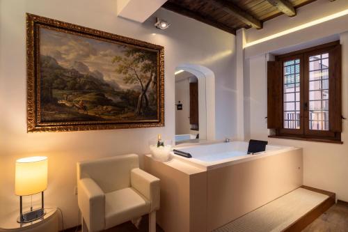 罗马吉格里多若套房酒店的带浴缸、椅子和绘画的浴室