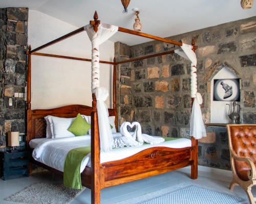 Dār Sawdāʼ萨马高地度假村的一间卧室配有一张四柱床和天鹅