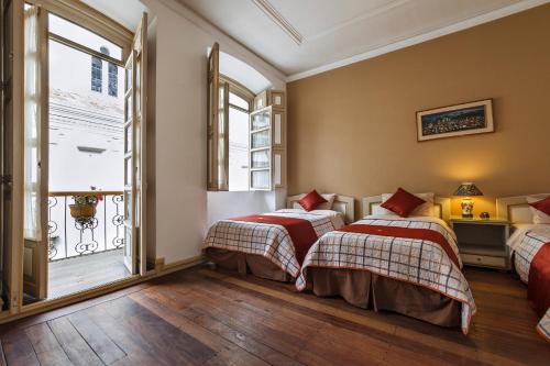 昆卡Hotel La Orquidea的带2扇窗户的客房内的2张床