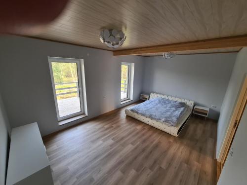 SondaSonda puhkemaja的一间卧室设有一张床和两个窗户。