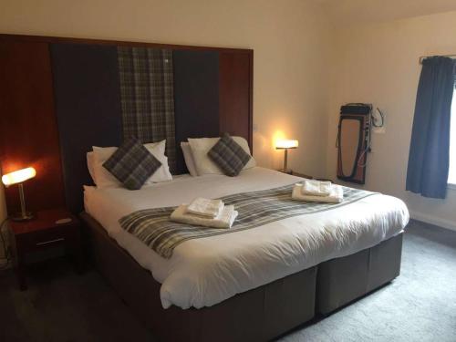 洛赫博伊代尔Polochar Inn的一间卧室配有一张大床和两条毛巾