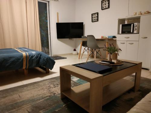 哈戈什里姆Cute Apartment hagoshrim的客厅配有咖啡桌和电视