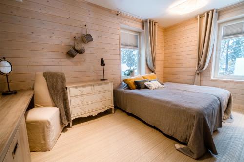 沃索Mere 38 Apartments的卧室设有木墙、一张床和椅子