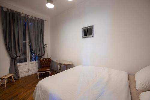 马赛Cosy République的卧室配有床、椅子和窗户。
