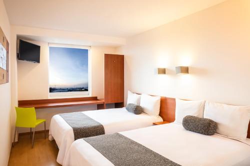 普埃布拉万普布拉芬撒酒店的酒店客房设有两张床和窗户。