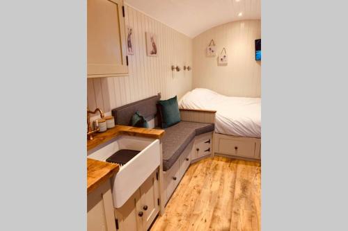 LlanddwyweLle Mary - Beautiful views, Hot tub, Secluded, Dog Welcome, Barmouth的一个带水槽的小厨房和一张位于客房内的床