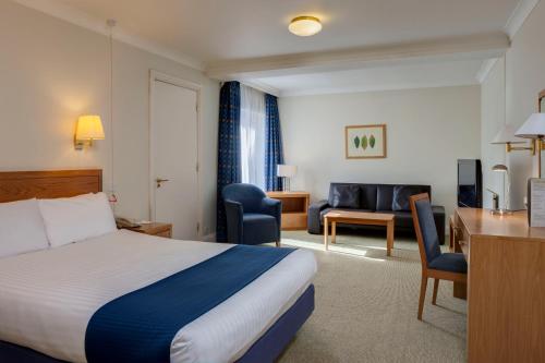 科尔切斯特假日科尔切斯特酒店的配有一张床和一张书桌的酒店客房