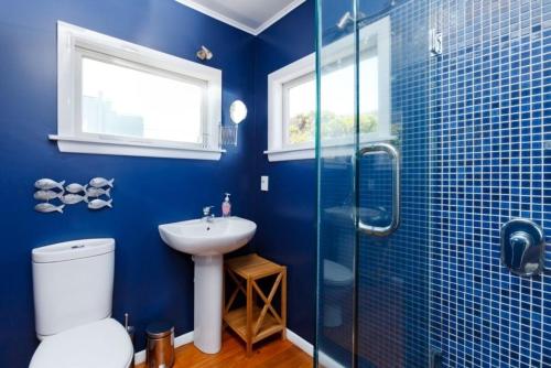 帕拉帕拉乌姆海滩Beach House - Paraparaumu Beach Holiday Home的蓝色的浴室设有卫生间和水槽