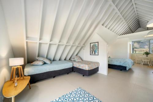 Te HoroThe Apartment - The Lodge Te Horo的一间卧室配有两张床和一张桌子。