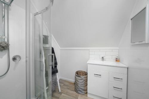 Te HoroThe Apartment - The Lodge Te Horo的白色的浴室设有水槽和淋浴。