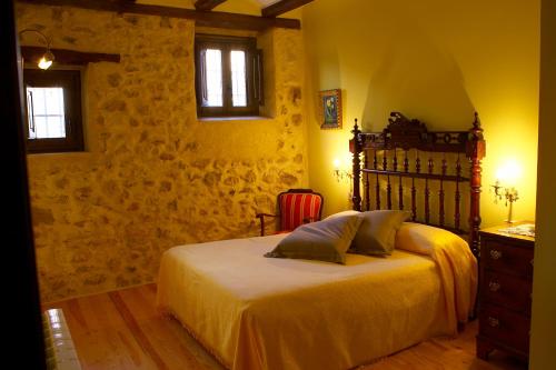 Jarque de la ValHotel La Val的一间卧室配有一张床、一个梳妆台和两个窗户。