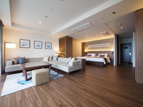 恩纳Hiyori Ocean Resort Okinawa的酒店客房设有床和客厅。