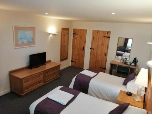 伊尔明斯特The Flying Fish Stables的酒店客房设有两张床和一台平面电视。