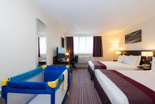 斯劳假日斯劳温莎酒店度假村的酒店客房设有两张床和电视。