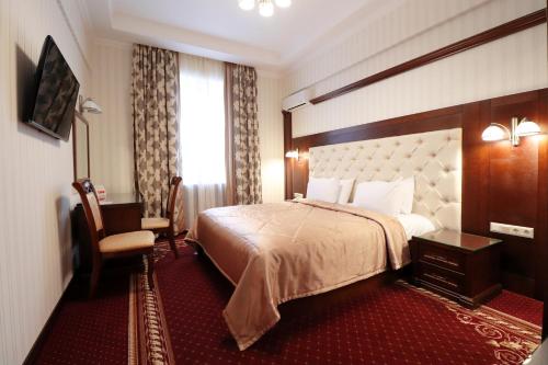 基辅乌克兰酒店的配有一张床和一把椅子的酒店客房