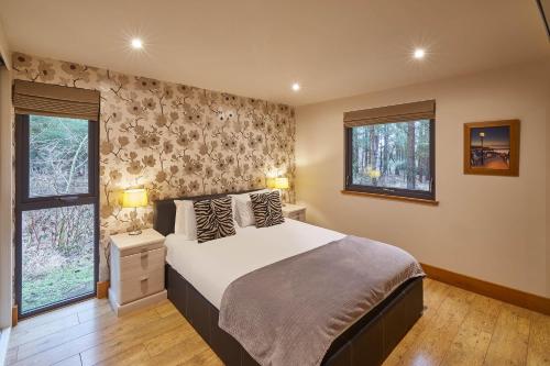 惠特比Host & Stay - Simon Howe Lodge的一间卧室设有一张大床和两个窗户。