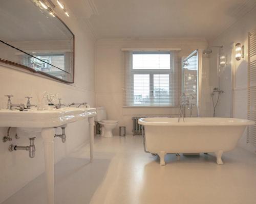 安特卫普ADA的白色的浴室设有浴缸和水槽。