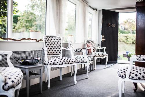 欧德尔Norsminde Kro Anneks的一间设有白色椅子、桌子和窗户的房间