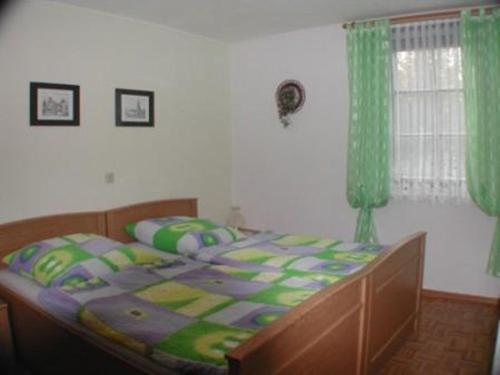 巴特弗兰肯豪森费德穆勒公寓的一间卧室配有一张带绿色窗帘的大床