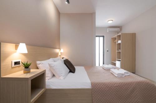 拉加纳斯Nikos & Maria Studios II的卧室配有一张带白色床单和枕头的大床。