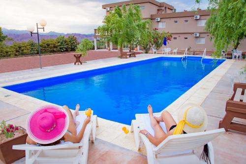乌尼翁镇Hotel Cuesta de Miranda的两人躺在游泳池旁的椅子上