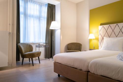 马斯特里赫特奥阔提尔酒店的酒店客房带床、椅子和窗户