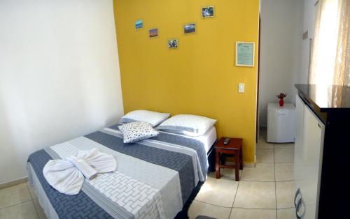 博尼图居白亚旅馆的一间卧室设有两张床和黄色的墙壁