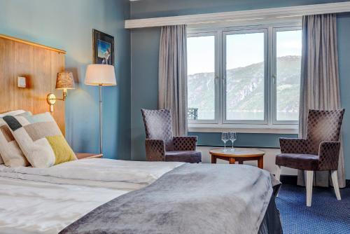 艾菲约德Vøringfoss Hotel的酒店客房设有一张床、两把椅子和一扇窗户。