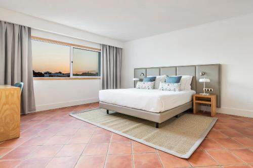 阿尔布费拉The Patio Suite Hotel的一间卧室设有一张床和一个大窗户