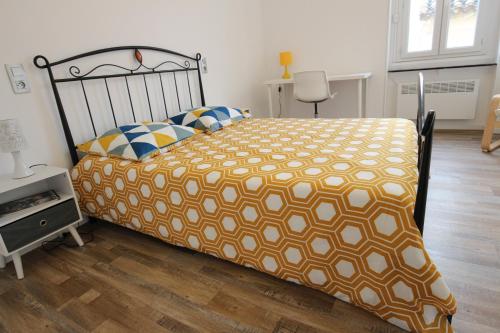 Portel-des-CorbièresT3 proche de la mer的一间卧室配有一张带橙色和白色棉被的床