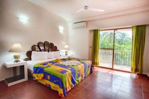 巴亚尔塔港Suites Plaza del Rio - Family Hotel Malecón Centro的一间卧室设有一张大床和一个大窗户