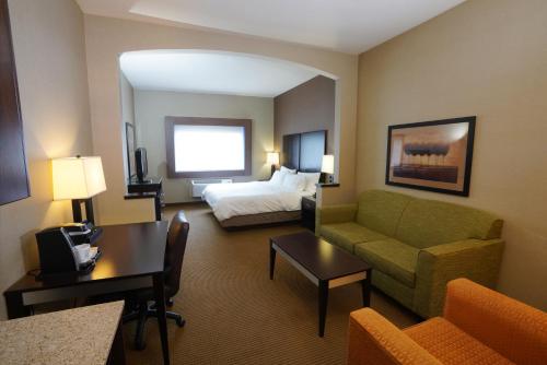 坎宁维尔Creekside Hotel & Suites的酒店客房,配有床和沙发