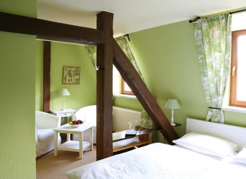 Oranienbaum-WörlitzHotel Zum Gondoliere的一间卧室设有绿色的墙壁和一张带梯子的床