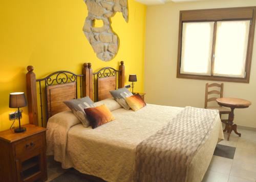 圣塞瓦斯蒂安伊图里科所兰德科萨酒店的一间卧室设有一张黄色墙壁的大床