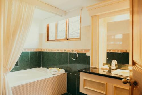 圣何塞艾尔罗德欧埃斯坦西亚精品酒店及牛排餐厅的带浴缸、水槽和镜子的浴室