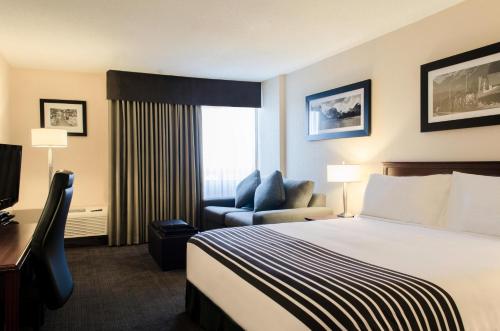 莱斯布里奇莱斯布里奇桑德曼酒店的配有一张床和一把椅子的酒店客房